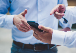 Two people looking at the same smartphone